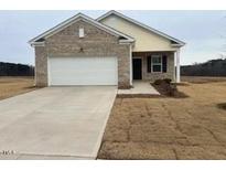 Brick and siding one-story house with a two-car garage and a neatly landscaped yard at 7290 Pilatus Ave, Spring Hope, NC 27882