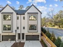 Modern townhome showcasing black-trimmed windows, dark garage doors, and a well-kept front yard at 811 Maple Berry Ln # 101, Raleigh, NC 27607