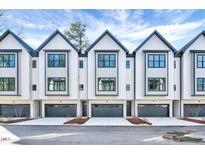 Beautiful exterior view of modern townhomes with sleek designs and a gray and white color palette at 811 Maple Berry Ln # 104, Raleigh, NC 27607