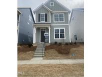 Charming two-story home with light green siding, black shutters, and a welcoming front porch and landscaped yard at 9212 Leaning Post Rd # 448, Wake Forest, NC 27587