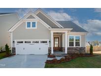 Charming single-Gathering home featuring a two-car garage, inviting entryway, and well-maintained landscaping at 239 Harvester Rd, Angier, NC 27501