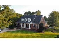 Charming brick home with a covered front porch, dormer windows, and well-manicured lawn at 166 Weldon Dr, Clayton, NC 27520