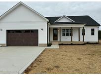 Charming new construction exterior featuring a covered porch and a two-car garage at 8536 Savage Rd, Spring Hope, NC 27882