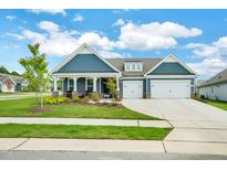 Inviting home exterior with a well-manicured lawn, blue siding, charming front porch, and a two-car garage at 1401 Black Locust Ln, Fuquay Varina, NC 27526