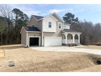 Charming two-story home with a covered porch, two-car garage, and a well-maintained lawn at 240 Fast Pitch Ln, Four Oaks, NC 27524
