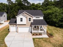 Beautiful two-story home with a two-car garage, front porch, and neutral tan and white siding at 240 Fast Pitch Ln, Four Oaks, NC 27524