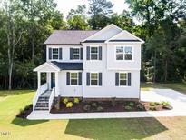 Charming two-story home featuring a well-manicured lawn and a welcoming front porch at 266 Fast Pitch Ln, Four Oaks, NC 27524