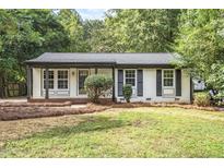 Charming ranch home with white brick exterior and landscaped lawn at 1029 Suffolk Blvd, Raleigh, NC 27603