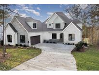 Beautiful two-story home with a brick and stone exterior and a curved driveway at 736 Golfers View Vw, Pittsboro, NC 27312