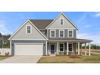 Charming two-story home featuring a two car garage, well-manicured lawn, and covered front porch at 1301 Cricket St, Elon, NC 27244