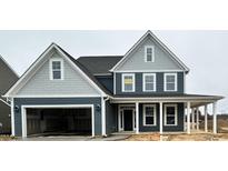 Two-story home featuring a two-car garage, covered porch, and eye-catching blue and gray color scheme at 1301 Cricket St, Elon, NC 27244