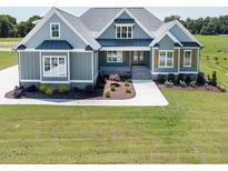 Charming exterior elevation with blue siding, manicured lawn, and inviting walkway at 70 Water Willow Ln, Zebulon, NC 27597