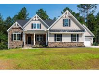 Charming exterior view of home with black shutters, stone accents, and manicured lawn at 160 Purslane Dr, Franklinton, NC 27525