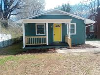 Charming home featuring a delightful front porch with a bright yellow door at 427 Jerkins St, Burlington, NC 27217