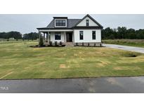 New construction home with a manicured lawn and landscaping and a covered porch at 5124 Grist Stone Way, Youngsville, NC 27596