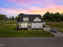Beautiful home featuring a lush front yard, and a covered front porch and a long driveway at 5124 Grist Stone Way, Youngsville, NC 27596