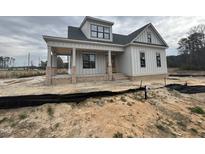 New construction two story home featuring a cozy covered porch with brick columns and fresh landscaping at 5124 Grist Stone Way, Youngsville, NC 27596