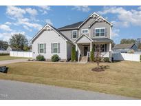 Charming two-story home with a welcoming front porch and manicured lawn at 1024 Jarrett Bay Rd, Willow Springs, NC 27592
