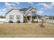 Charming two-story home featuring a welcoming front porch and well-manicured lawn under a sunny sky at 1024 Jarrett Bay Rd, Willow Springs, NC 27592