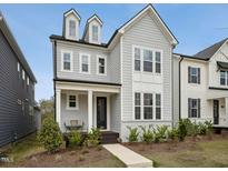Charming two-story home featuring dormer windows, a welcoming front porch, and landscaped front yard at 1425 Patchings Ln, Knightdale, NC 27545