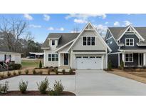 Beautiful two-story home featuring a classic white garage and a well-maintained front yard at 418 S Cross St, Youngsville, NC 27596