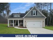 Charming home featuring a manicured lawn, two-car garage and a welcoming front porch at 50 N Rowsham Pl, Smithfield, NC 27577
