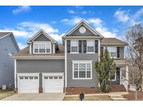 Beautiful two-story home featuring gray siding, white trim, dormers, and a two-car garage at 10877 Bedfordtown Dr, Raleigh, NC 27614
