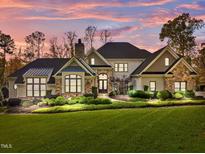Stunning home with stone accents, lush landscaping, and a charming entrance under a beautiful sky at 110 Bywater Way, Chapel Hill, NC 27516
