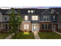 Charming townhome with a brick facade, blue door, and a well-manicured lawn at 937 Alma Railway Dr # 555, Wake Forest, NC 27587