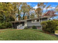 Ranch style home with gray siding, white trim, and a landscaped lawn at 2600 Wade Ave, Raleigh, NC 27607