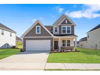 Charming two-story home featuring a two-car garage and a well-manicured front yard at 604 Spellbrook Rd, Zebulon, NC 27597
