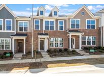 Charming townhomes showcase brick and siding exteriors, complemented by manicured landscaping and inviting entryways at 255 Chesapeake Commons St # 90, Garner, NC 27529