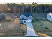 Charming two-story home features a well-manicured lawn, a concrete driveway, and attached garage at 316 Robert Howe Dr, Fuquay Varina, NC 27526