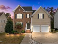 Charming two-story home featuring a brick and siding exterior, a two-car garage and beautifully landscaped front yard at 722 Redford Place Dr, Rolesville, NC 27571