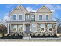 Two-story house with stone and shingle accents, front porch, and landscaping at 87 Browning Mill Dr, Wendell, NC 27591