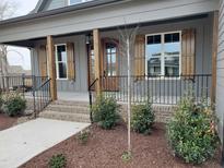 Charming front porch with wooden columns and shutters, complemented by landscaped greenery at 20 Water Willow Ln, Zebulon, NC 27597