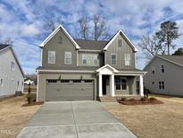 Two-story house with gray siding, a white porch, and a two-car garage at 2401 Terri Creek N Dr # 08, Fuquay Varina, NC 27526