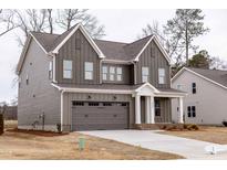 Charming two-story home with gray siding, white trim, and a two-car garage at 2401 Terri Creek N Dr # 08, Fuquay Varina, NC 27526