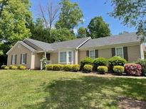 Inviting single-story home with manicured front lawn and colorful landscaping at 6220 Sweden Dr, Raleigh, NC 27612