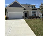 Charming single-Gathering home with a two-car garage and well-maintained landscaping on a sunny day at 579 Winding Creek Dr, Lillington, NC 27546