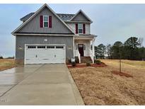 Charming two-story home featuring a two-car garage and beautiful, newly installed landscaping at 95 Mapledale Ct, Benson, NC 27504