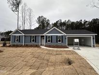 Gray house with stone accents, attached garage, and landscaping at 39 N Rowsham Pl, Smithfield, NC 27577
