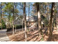 Secluded home exterior surrounded by mature trees offering privacy and curb appeal at 106 Springbrook Pl, Cary, NC 27518