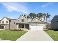 Two-story home featuring a two-car garage, manicured lawn, and neutral siding at 1221 Dimaggio Dr # 10, Raleigh, NC 27616