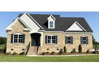 Charming brick home with black shutters, and beautifully landscaped front yard on a sunny day at 1665 S Old Carriage Rd, Rocky Mount, NC 27804
