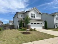 Charming two-story home featuring a well-manicured lawn, a two car garage, and beautiful landscaping at 2117 Attend Xing, Fuquay Varina, NC 27526