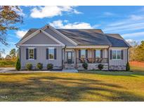 Charming single-story home featuring a welcoming front porch and meticulously landscaped front yard at 3217 Satterwhite Point Rd, Henderson, NC 27537
