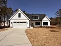Charming new construction home with white siding, black trim, and a welcoming front entrance at 103 Roma Gora Ct, Princeton, NC 27569