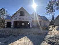 New construction home showcasing framing and initial stages, with a bright, sunny sky overhead at 104 Roma Gora Ct, Princeton, NC 27569