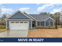 Charming single-story home with blue siding, a two-car garage, and freshly sodded front yard at 613 Tuscany Cir, Princeton, NC 27569